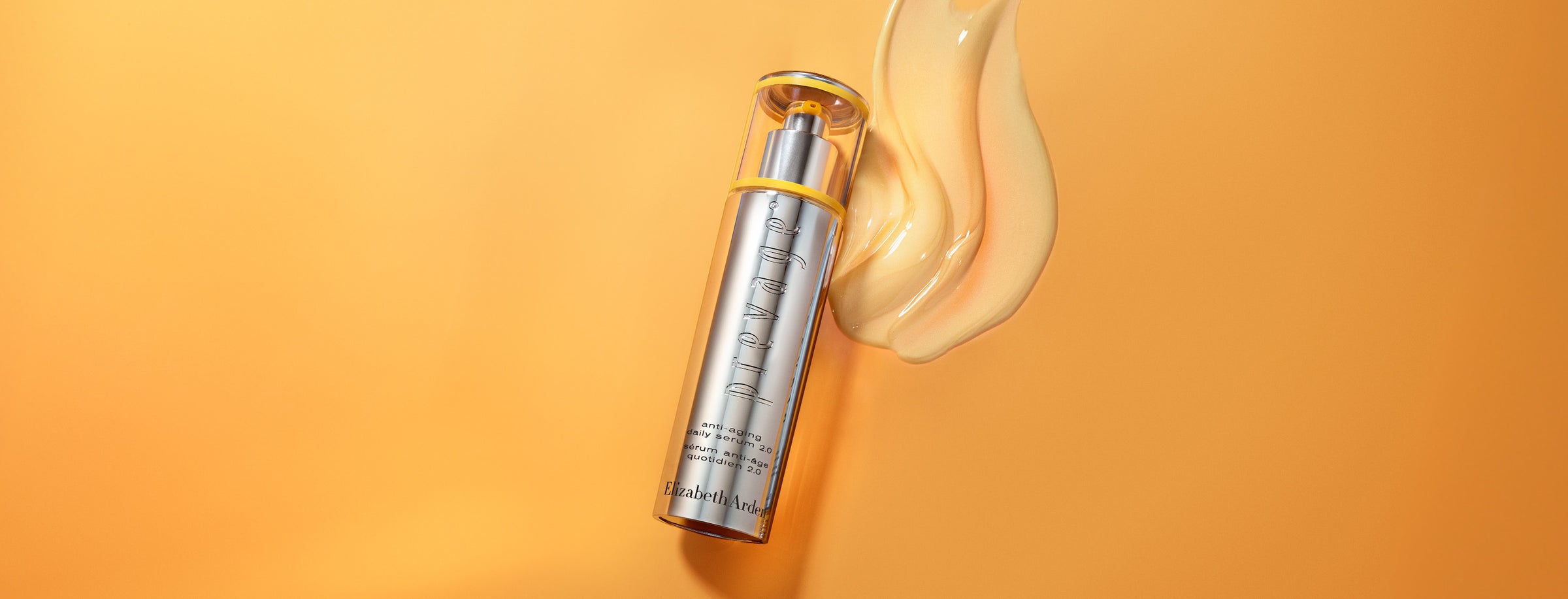 Skincare serum bottle with a stream of cream on an orange background