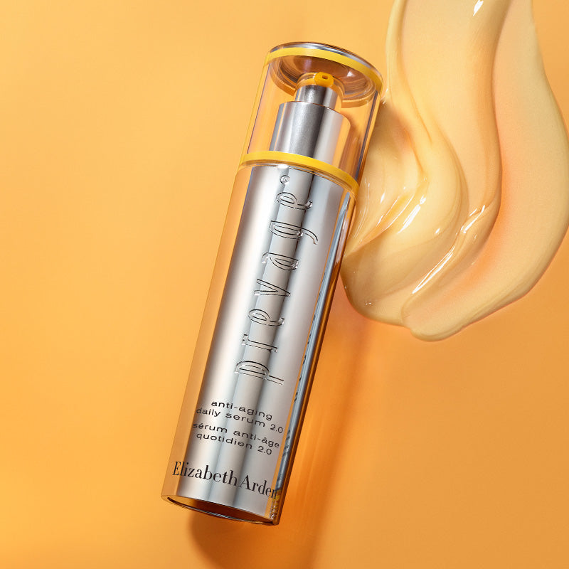 Skincare serum bottle with a yellow cap on an orange background