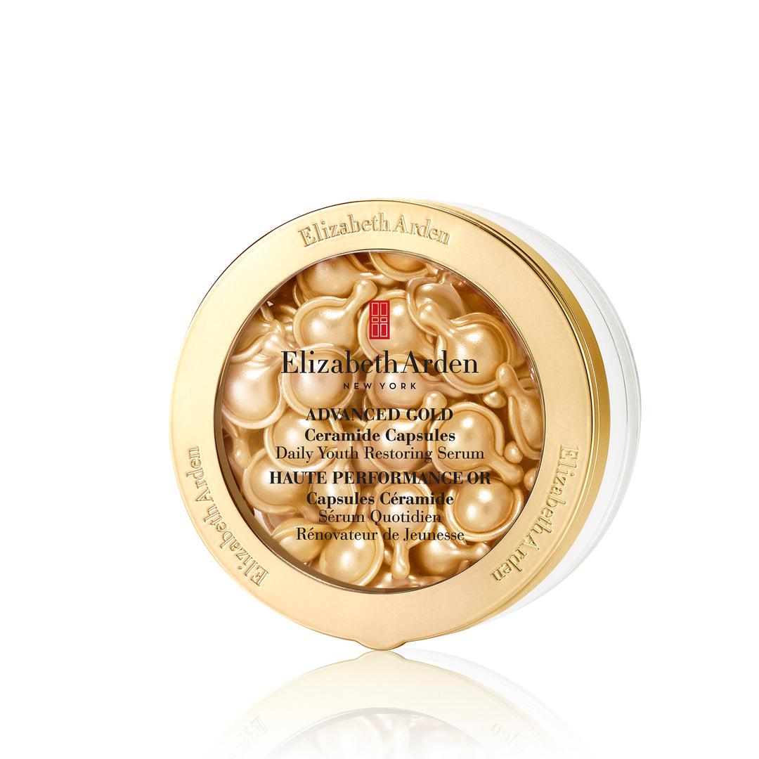 Elizabeth Arden Advanced Gold Ceramide Capsules serum in a round gold container with a clear lid showing the golden capsules inside, on a white background with a reflection.