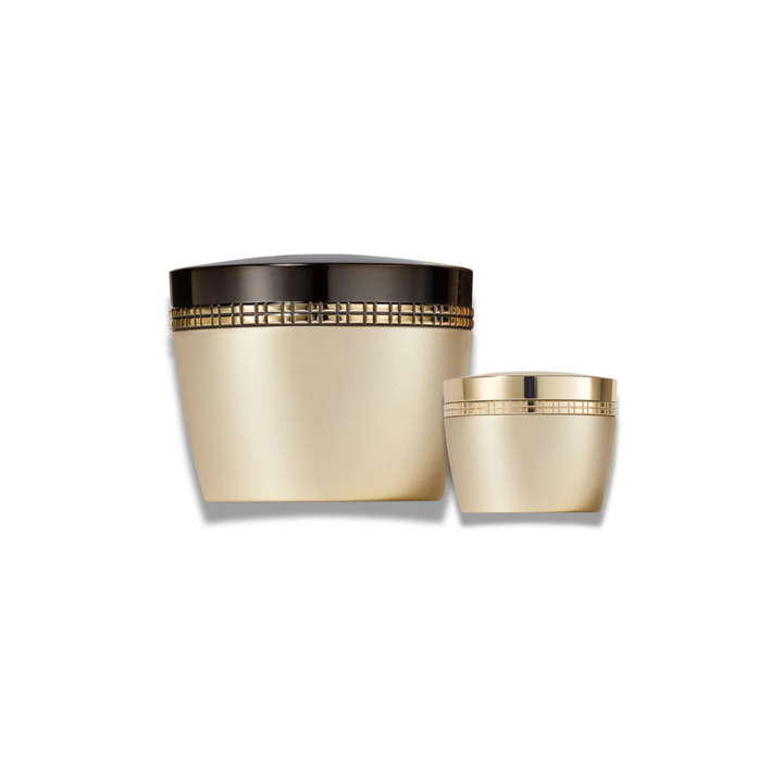 Two elegant cosmetic jars with a metallic champagne-gold finish and a black lid, displayed on a clean white background.