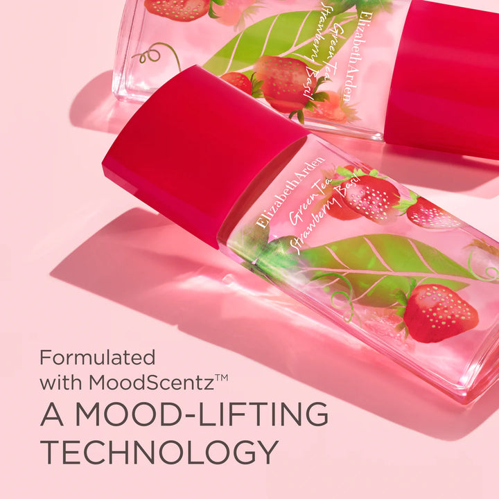 A clear cosmetic bottle with a bright pink cap and printed strawberry-and-leaf graphics, shown on a pink background with additional bottles and large text reading 'Formulated with MoodScentz™ A MOOD-LIFTING TECHNOLOGY.'.