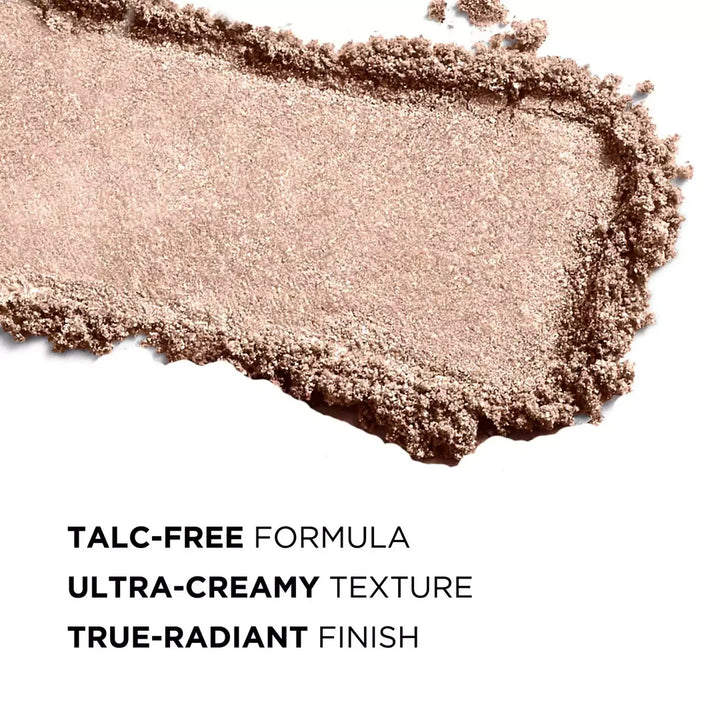 A textured swipe of shimmering makeup powder in a warm taupe-beige shade on a white background, with text below reading 'TALC-FREE FORMULA', 'ULTRA-CREAMY TEXTURE', and 'TRUE-RADIANT FINISH'.