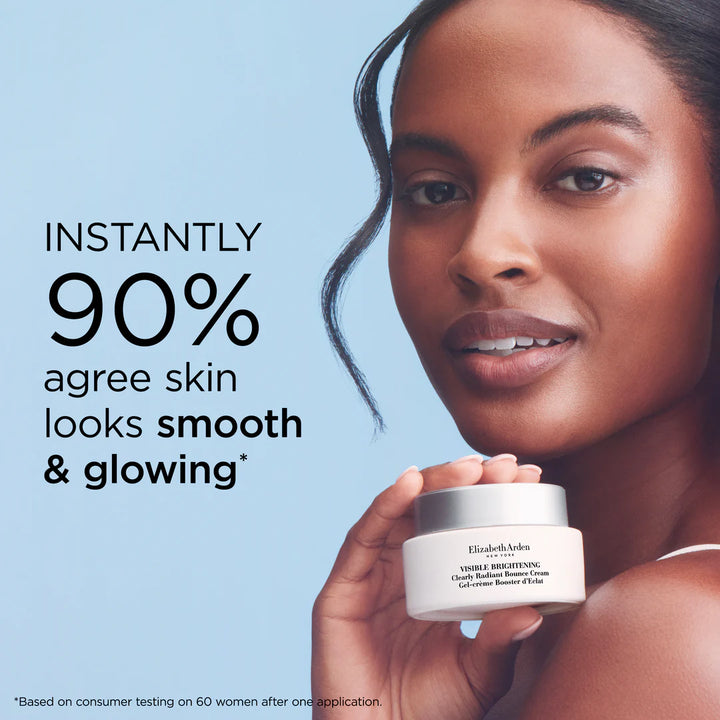A woman holds an open white jar of Elizabeth Armani Visibly Brightening Cleansing Radiant Serum against a light blue background, with promotional text on the left reading 'INSTANTLY 90% agree skin looks smooth & glowing'.