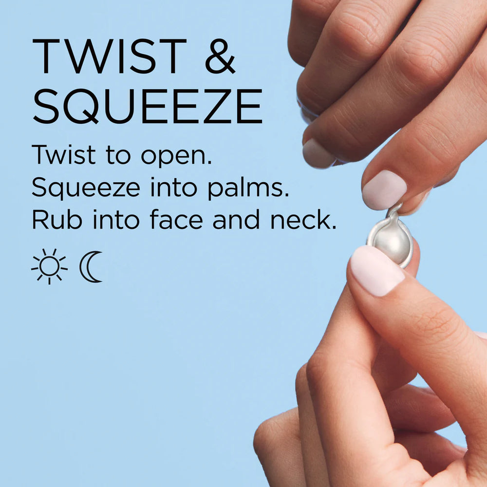 Hands twisting and squeezing a skincare product onto the palm against a light blue background.