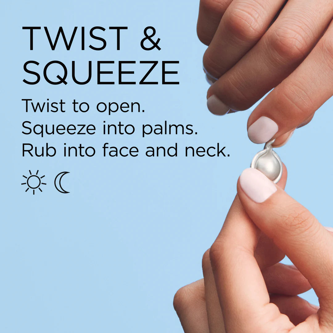 Hands twisting and squeezing a skincare product onto the palm against a light blue background.