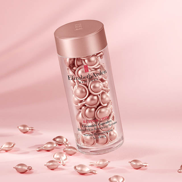 Retinol + HPR Ceramide Capsules on an angle with a pink background