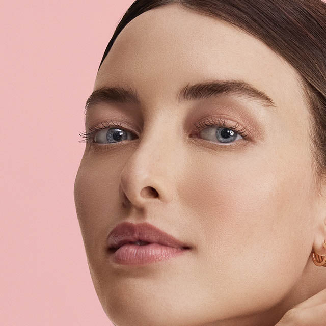 Close-up of a woman's face with a pink background