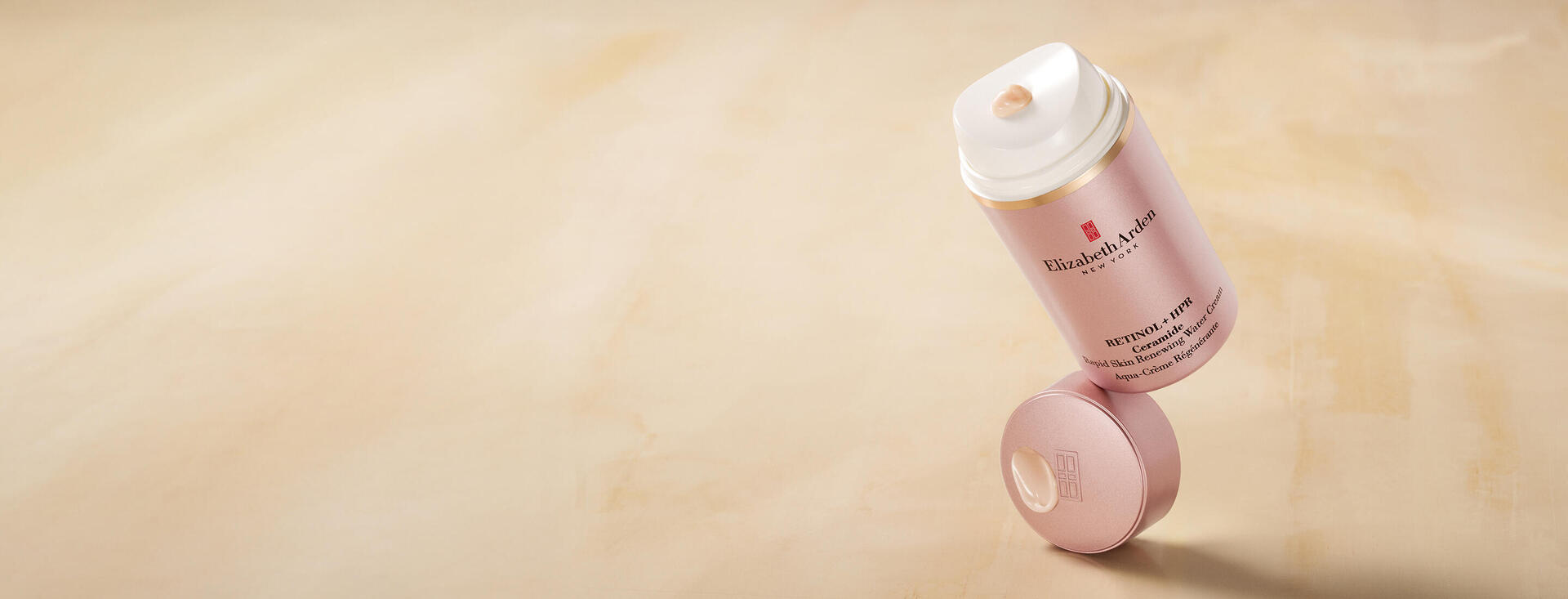 Retinol + HPR Ceramide Water Cream balancing on top of cap with yellow beige background. Desktop Version. 
