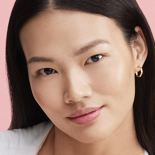 Close-up of a woman's face with a pink background